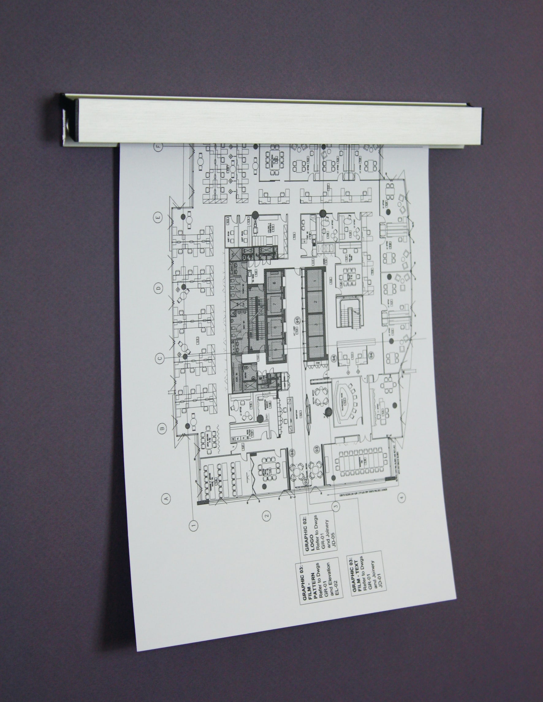 Aluminum Paper Hanger rail holding a printed floor plan